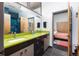 Bright bathroom featuring a double sink with modern fixtures and a stylish green countertop at 8 Lindenwood Dr, Littleton, CO 80120