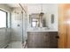 Modern bathroom featuring a double vanity, sleek fixtures, and a glass-enclosed shower with tile surround at 8 Lindenwood Dr, Littleton, CO 80120