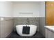 Modern bathroom with an oval soaking tub and stylish gray and white tile at 8 Lindenwood Dr, Littleton, CO 80120