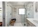 Luxurious bathroom with a large glass shower, dual showerheads and stone tile at 8 Lindenwood Dr, Littleton, CO 80120