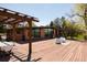 Expansive wooden deck with dining area and pergola, perfect for outdoor entertaining and relaxation at 8 Lindenwood Dr, Littleton, CO 80120