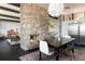 Open dining area with stone fireplace feature, dark hardwood floors, and unique lighting fixture at 8 Lindenwood Dr, Littleton, CO 80120