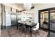 Open dining area with an adjacent modern kitchen, featuring stainless steel appliances, and a large window at 8 Lindenwood Dr, Littleton, CO 80120