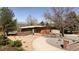 A modern, single-story home boasts a unique design and meticulously landscaped front yard with a mountain view at 8 Lindenwood Dr, Littleton, CO 80120