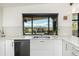 Modern kitchen features sleek white cabinets, stainless steel appliances, and a large window with mountain views at 8 Lindenwood Dr, Littleton, CO 80120