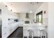 Bright, spacious kitchen with white cabinets, stainless appliances, quartz countertops, and a breakfast bar area with seating at 8 Lindenwood Dr, Littleton, CO 80120