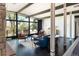 Sunlit living room boasts a stone fireplace, dark wood floors, and large windows overlooking an outdoor deck at 8 Lindenwood Dr, Littleton, CO 80120
