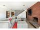 Open-concept living room with modern staircase, brick accent wall and fireplace, creating a cozy atmosphere at 8 Lindenwood Dr, Littleton, CO 80120