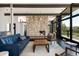 Elegant living room with a grand stone fireplace, dark wood floors, and expansive windows overlooking a serene outdoor space at 8 Lindenwood Dr, Littleton, CO 80120