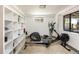 Workout area featuring exercise equipment, a large window, and shelving at 8 Lindenwood Dr, Littleton, CO 80120