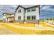 New construction home with stone accents, light siding, and dark trim under a cloudy sky at 2197 S Jackson Gap St, Aurora, CO 80018