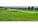 Lush green golf course with a sand trap, putting green, and a neighborhood in the background at 2197 S Jackson Gap St, Aurora, CO 80018