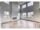 Bright living room with high ceilings, a modern fireplace, and large windows offering ample natural light at 2197 S Jackson Gap St, Aurora, CO 80018