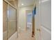 Bathroom with glass shower/tub, tile floor, toilet, and access to hallway at 1275 Fairfax St, Denver, CO 80220