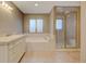 Clean bathroom features shower stall, soaking tub, single vanity and earth-toned tile at 1275 Fairfax St, Denver, CO 80220