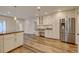 Bright kitchen features stainless steel refrigerator, white cabinets, and beautiful granite countertops at 1275 Fairfax St, Denver, CO 80220