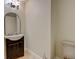 Traditional powder room with black vanity, arched mirror, and neutral walls at 1275 Fairfax St, Denver, CO 80220