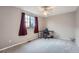 Bedroom with neutral walls, carpet, window with red curtains and a desk at 12362 Nate Cir, Parker, CO 80134