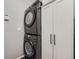 Stackable washer and dryer near grey closet with black handles in the laundry area at 12362 Nate Cir, Parker, CO 80134
