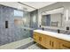 Bathroom with walk-in shower, dual sink vanity, and modern tile at 2046 S Quitman St, Denver, CO 80219