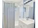 Updated bathroom with shower-tub combo and white vanity at 2046 S Quitman St, Denver, CO 80219