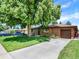 Charming single-story brick home featuring an attached garage and a spacious driveway at 2046 S Quitman St, Denver, CO 80219