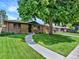 Charming single-story brick home with a well-manicured lawn and mature tree at 2046 S Quitman St, Denver, CO 80219