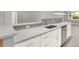 Beautiful kitchen featuring white cabinets, stainless steel appliances and grey quartz countertops at 2046 S Quitman St, Denver, CO 80219