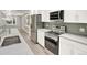 Modern kitchen with stainless steel appliances, white cabinets, and a mosaic tile backsplash at 2046 S Quitman St, Denver, CO 80219
