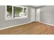 Bright and airy living room with hardwood floors, fresh paint, and a window with natural light at 2046 S Quitman St, Denver, CO 80219