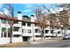 Exterior view of building with several balconies, green trim, and mature trees at 611 E 7Th Ave, Denver, CO 80203