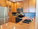 Updated kitchen boasts stainless appliances, wood cabinets, granite counters, and bar seating at 611 E 7Th Ave, Denver, CO 80203