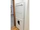 Stacked washer and dryer with tile floors near a carpeted room at 611 E 7Th Ave, Denver, CO 80203