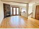 Open living room featuring a stone fireplace, hardwood floors, and access to the deck at 611 E 7Th Ave, Denver, CO 80203