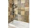 Close up of a shower and tub combination featuring stone tile surround at 611 E 7Th Ave, Denver, CO 80203