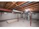 Spacious unfinished basement with exposed ceiling, utilities, and red support beams at 1409 S Moline St, Aurora, CO 80012