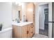 Bathroom features a light wood vanity with storage, a white sink, and black hardware at 1409 S Moline St, Aurora, CO 80012