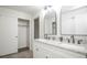 Dual sink bathroom vanity with granite counters, black faucets, and a view of the closet at 1409 S Moline St, Aurora, CO 80012
