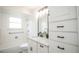 Well-lit bathroom with white tiled shower/tub and a vanity with white granite counters and black hardware at 1409 S Moline St, Aurora, CO 80012