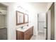 Double vanity in a bathroom, with wood cabinets, framed mirrors, and tile flooring at 1409 S Moline St, Aurora, CO 80012