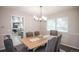 This bright dining room has gray upholstered chairs around a wood table with a chandelier overhead at 1409 S Moline St, Aurora, CO 80012