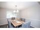 Bright dining room features a chandelier, stylish gray chairs and a natural wood table with seating for six at 1409 S Moline St, Aurora, CO 80012