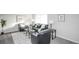Bright living room with black leather furniture, neutral walls, bay window, and stylish decor at 1409 S Moline St, Aurora, CO 80012