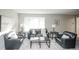 Sunlit living room features neutral decor with comfortable seating arrangement and a bay window at 1409 S Moline St, Aurora, CO 80012