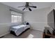 Neutral toned bedroom with a small bed, ceiling fan, window, and a large television at 19414 E Mann Creek Dr # C, Parker, CO 80134