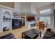 Bright open-concept living room features a fireplace, kitchen view, and dining area bathed in natural light at 19414 E Mann Creek Dr # C, Parker, CO 80134