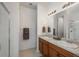 Bright bathroom featuring a double sink vanity, large mirror, and glass enclosed shower at 6317 Vista Cliff Loop, Castle Rock, CO 80104