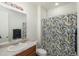 Bright bathroom featuring a single sink vanity, large mirror, and shower with decorative curtain at 6317 Vista Cliff Loop, Castle Rock, CO 80104