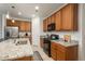 Modern kitchen featuring stainless steel appliances, granite countertops and wood cabinets with a black gas stove at 6317 Vista Cliff Loop, Castle Rock, CO 80104