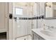 Elegant bathroom featuring a glass shower, a marble vanity, and classic black and white tile accents at 4054 Wyandot St, Denver, CO 80211